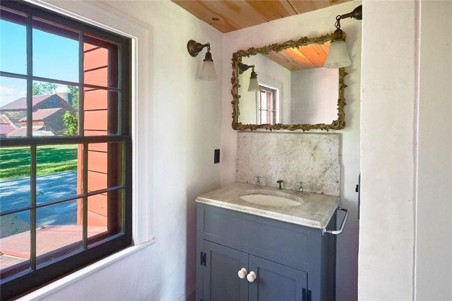 Bathroom with wood ceiling, vanity, a healthy amount of sunlight, and decorative backsplash | Image 12