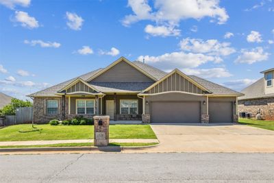 Craftsman-style home with a garage, central AC, and a front lawn | Image 1