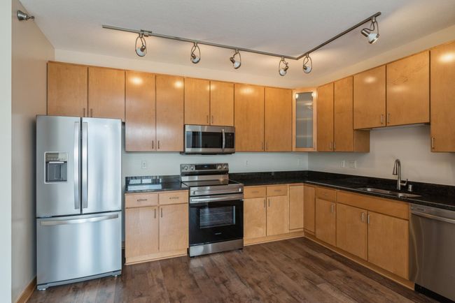 The kitchen offers wide countertops and a wealth of storage, ensuring a space that's both functional and welcoming.(The photos are of unit 401. Owned by the same person and finishes that are VERY similar) | Image 4