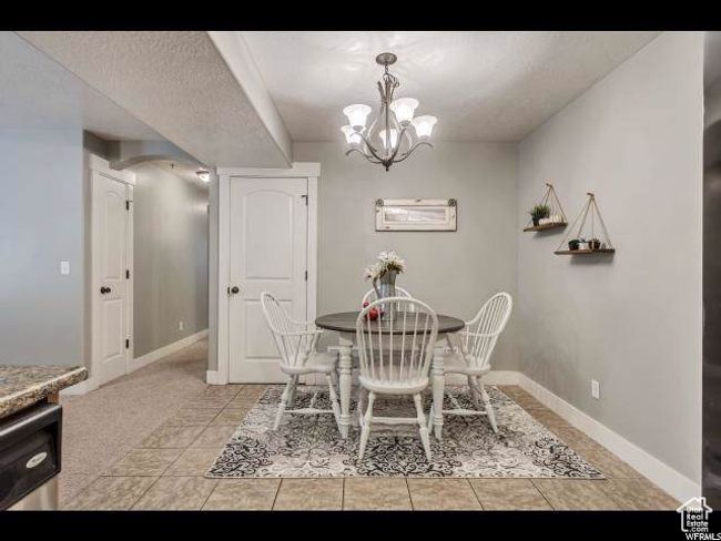 Dining room featuring a chandelier, baseboards, and light tile patterned floors | Image 4