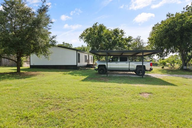 View of yard featuring a detached carport and driveway | Image 7