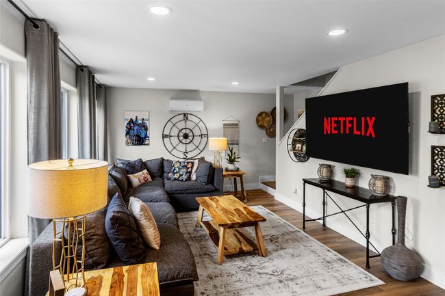 Living area featuring a wall mounted air conditioner, wood finished floors, and recessed lighting | Image 60