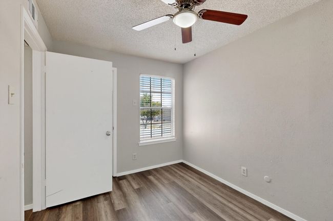 Spare room with a textured ceiling, wood finished floors, and a ceiling fan | Image 23
