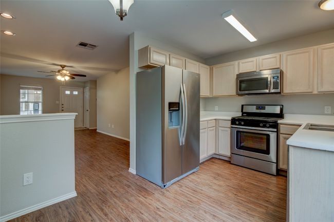 Kitchen with appliances with stainless steel finishes, light wood-type flooring, baseboards, light countertops, and recessed lighting | Image 14