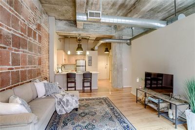 Living room with a high ceiling, sink, and light wood-type flooring | Image 1