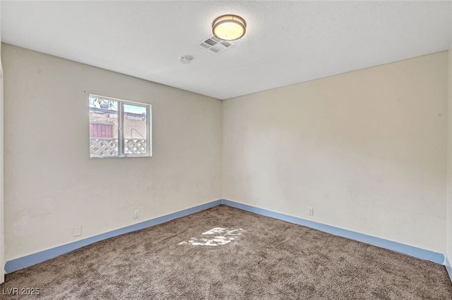 Carpeted empty room with a smoke detector and baseboards | Image 20