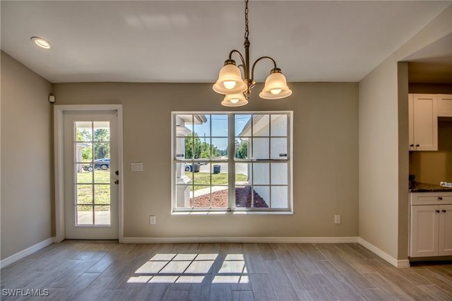Unfurnished dining area featuring a chandelier, light wood finished floors, and baseboards | Image 12