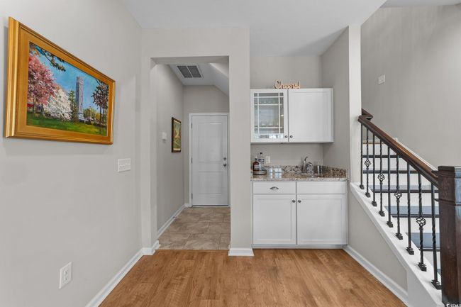 Indoor wet bar with light wood-style flooring, baseboards, and stairway | Image 22
