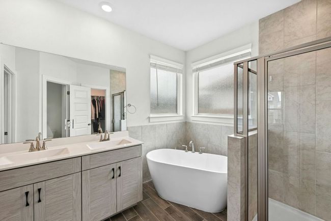 Elegant primary bathroom featuring a deep tub, separate shower and dual sinks | Image 20