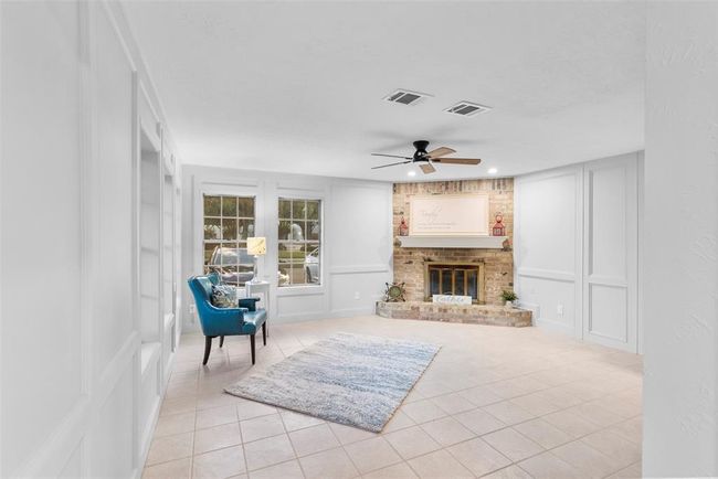 Gather in the spacious living room with abundant natural lighting & beautiful fireplace. | Image 7