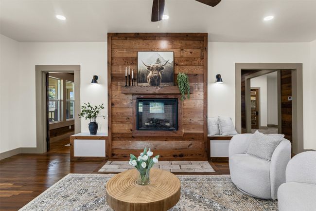 Living area featuring wood finished floors, a ceiling fan, a multi sided fireplace, baseboards, and recessed lighting | Image 11