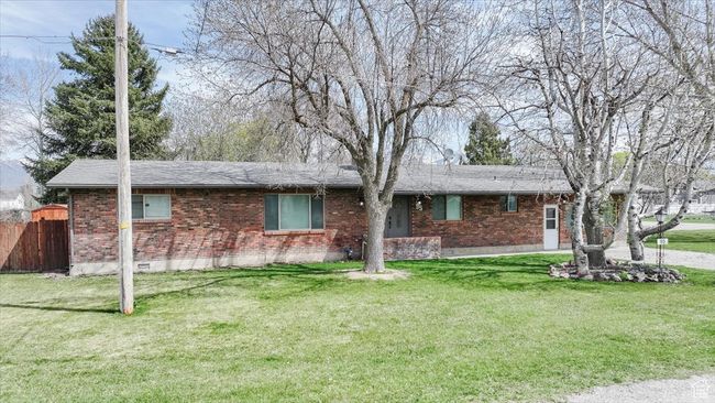 Single story home with brick siding, a front yard, and fence | Image 49