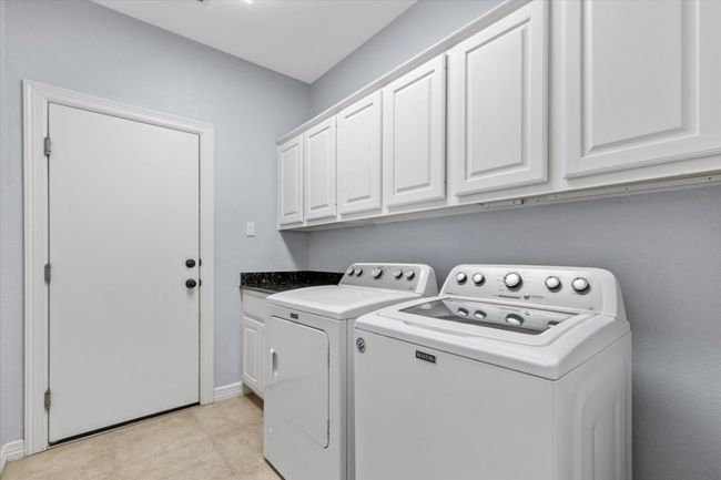 Featuring an oversized laundry room, complete with ample counter space for folding clothes and plenty of cabinets for storage. | Image 29
