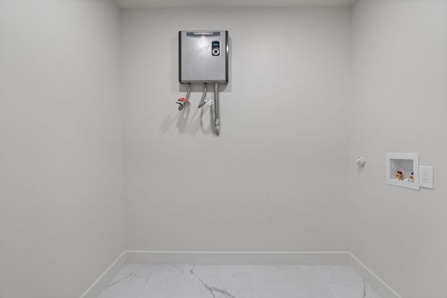 Laundry room featuring hookup for a gas dryer, baseboards, washer hookup, and light marble finish floors | Image 20