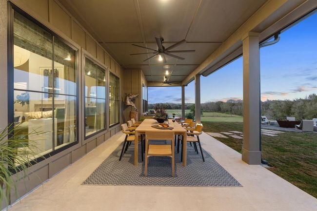 The covered outdoor patio is spacious and beckons everyone outdoors. Ceiling fans add additional air circulation in addition to the prevailing breezes from the open pasture beyond the fenceline. | Image 36