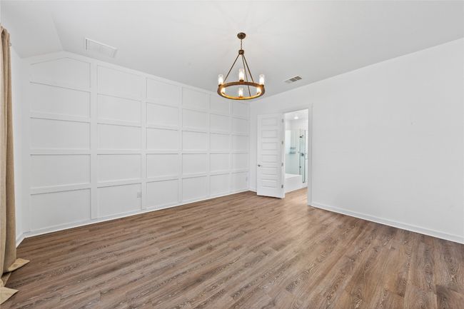 Unfurnished room featuring visible vents, vaulted ceiling, wood finished floors, and a chandelier | Image 20