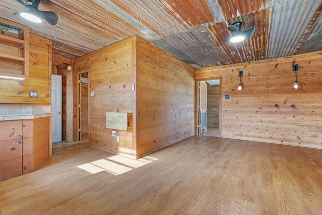 Empty room featuring wooden walls and light wood-type flooring | Image 12
