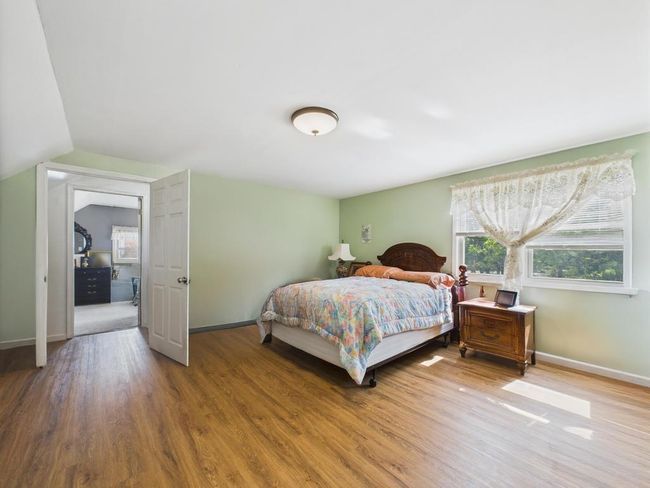 Bedroom featuring wood finished floors and lofted ceiling | Image 15