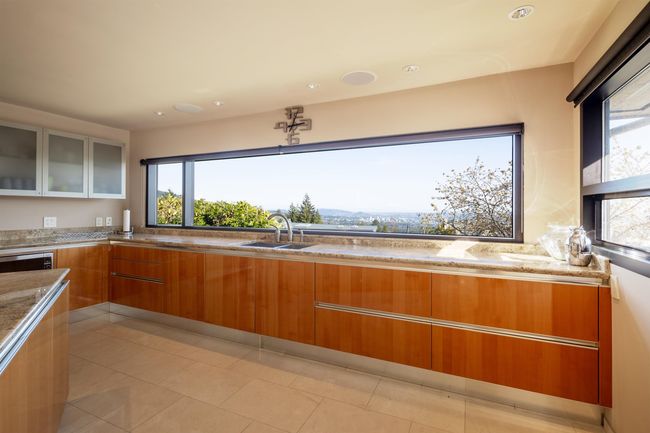 Kitchen with a sink, light stone countertops, modern cabinets, and brown cabinetry | Image 6