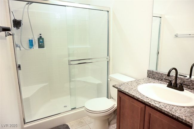 Bathroom featuring vanity, tile patterned flooring, a shower stall, and toilet | Image 17