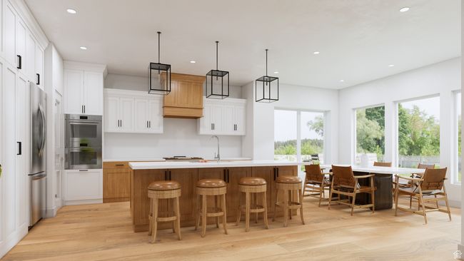 Kitchen with a kitchen island with sink, light wood-type flooring, light countertops, appliances with stainless steel finishes, and recessed lighting | Image 4