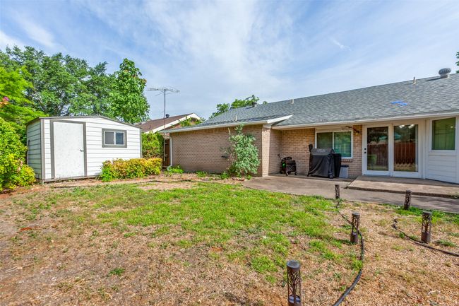 View of green lawn with a patio and a storage unit | Image 12