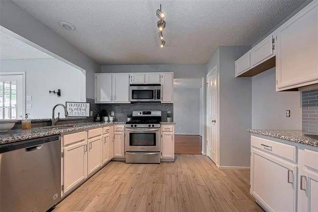 The kitchen is a great space to gather while being available to those in the sun room and also to the Den | Image 10