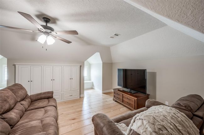 Discover versatile living space upstairs, accessible via the garage. Ideal as a recreation room or bedroom suite, it features charming pitched ceilings, built-in cabinets, drawers, and two cozy bench seats. Perfect for relaxation or entertainment. | Image 25