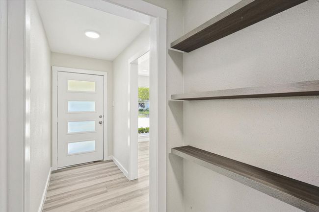 Entryway with baseboards, light wood-style flooring, and a textured wall | Image 6