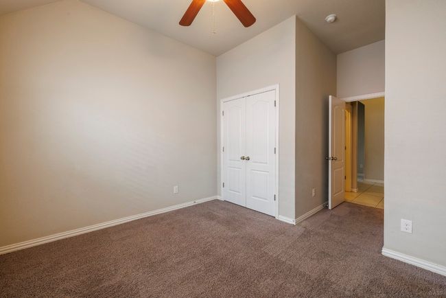 Unfurnished bedroom featuring carpet floors, a closet, a ceiling fan, and a high ceiling | Image 25