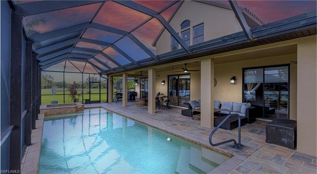 Outdoor pool with glass enclosure, outdoor lounge area, an in ground hot tub, ceiling fan, and a patio area | Image 27