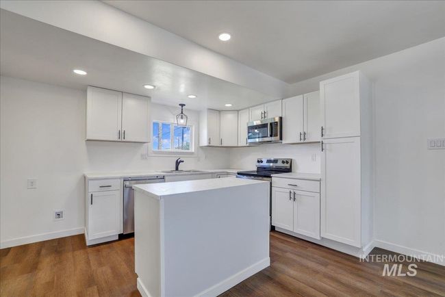 Kitchen featuring appliances with stainless steel finishes, dark wood-style flooring, white cabinetry, and recessed lighting | Image 10