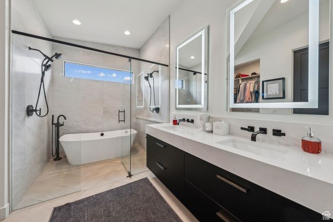 Full bath featuring a shower stall, a soaking tub, a sink, and double vanity | Image 36