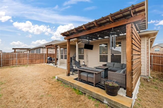 Rear view of property with an outdoor living space with a fire pit, a patio area, a fenced backyard, and a pergola | Image 28