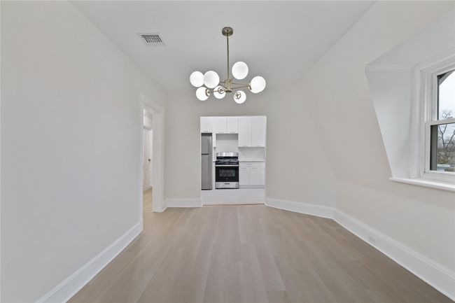 Unfurnished dining area with a chandelier, light wood-type flooring, visible vents, and baseboards | Image 11