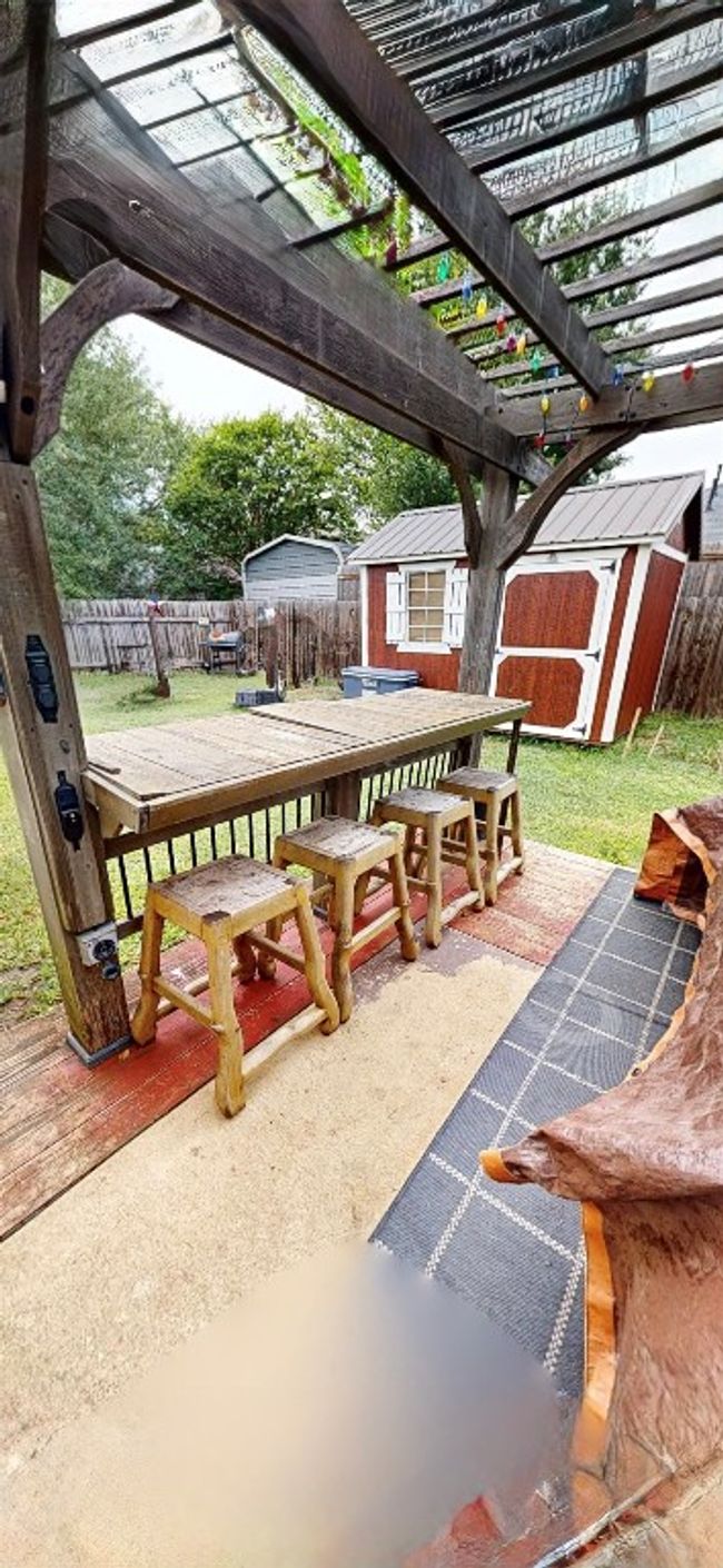 Fenced backyard with a shed, outdoor dining area, and a pergola | Image 8