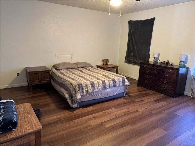 Bedroom with ceiling fan, dark hardwood / wood-style flooring, and a textured ceiling | Image 18