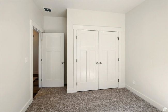 Unfurnished bedroom featuring carpet floors, baseboards, and a closet | Image 26