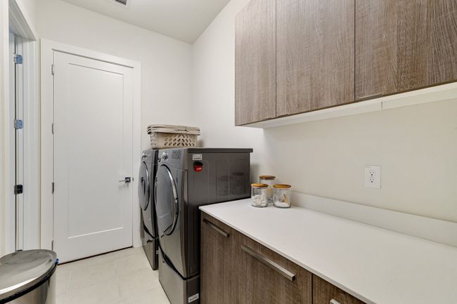 Washroom with cabinet space, washer and clothes dryer, and light tile patterned floors | Image 7