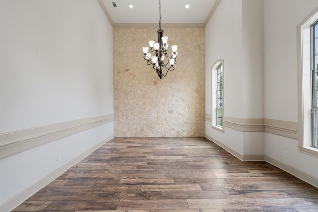 Unfurnished dining area featuring a healthy amount of sunlight, ornamental molding, and a notable chandelier | Image 5