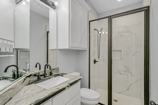 Bathroom with a marble finish shower, toilet, and vanity | Image 20