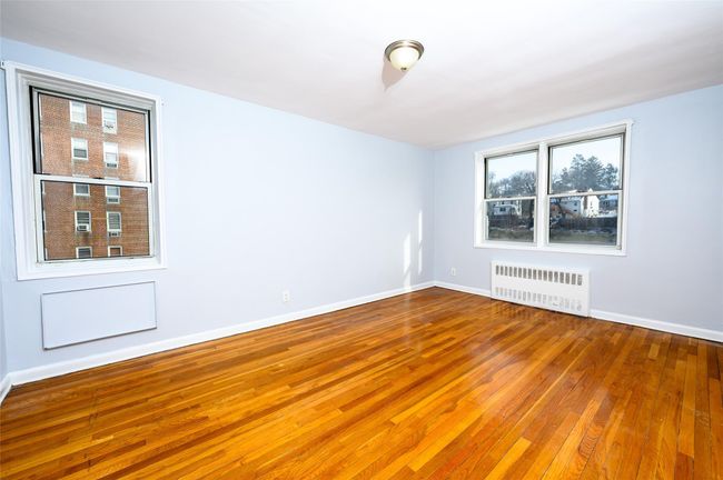 Spare room featuring radiator and hardwood / wood-style floors | Image 10