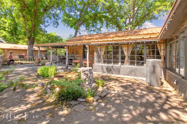 View of outdoor courtyard with flower beds and water feature. | Image 34