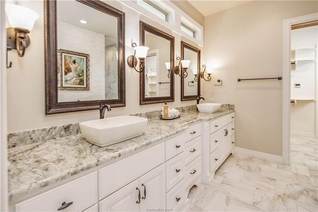 Full bath featuring double vanity, a sink, marble finish floor, and baseboards | Image 18
