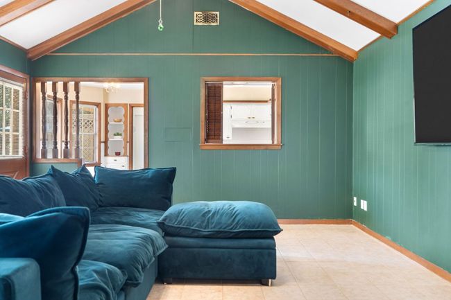 Tiled living room featuring wood panel walls and baseboards | Image 16