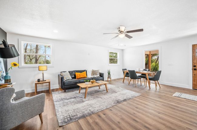 Living room featuring baseboards, light wood finished floors, and a ceiling fan | Image 5