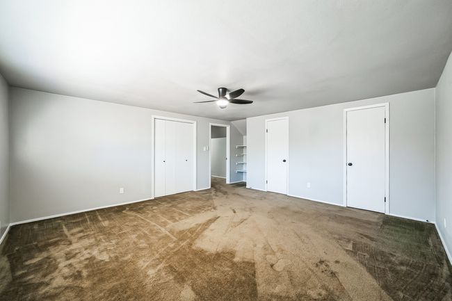 Unfurnished bedroom featuring multiple closets, carpet, and a ceiling fan | Image 18