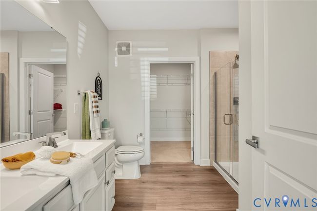 Full bath with wood finished floors, a spacious closet, vanity, and a shower stall | Image 15