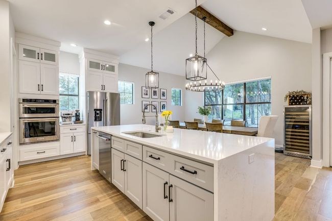 The stunning kitchen features an oversized island with quartz waterfall edge that sets the tone. | Image 12