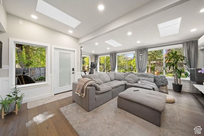 Living room featuring a skylight, wood-type flooring, vaulted ceiling, and recessed lighting | Image 18